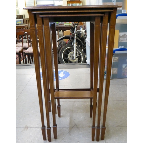 21 - A nesting set of three ebony and string inlaid, mahogany occasional tables, raised on square, tapere... 