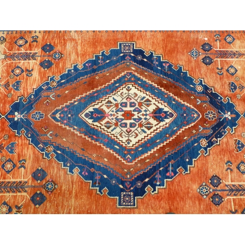 319 - A Persian rug, decorated with floral motifs, on a red and blue ground  72