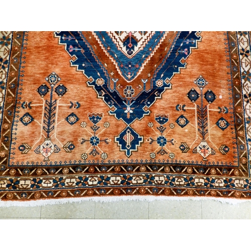 319 - A Persian rug, decorated with floral motifs, on a red and blue ground  72