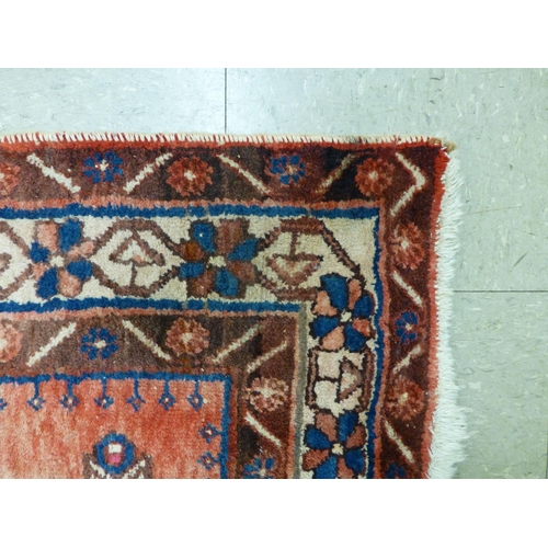 319 - A Persian rug, decorated with floral motifs, on a red and blue ground  72