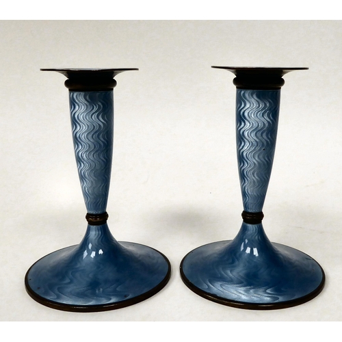 69 - A pair of Marius Hammer, Norwegian silver gilt and engine turned, powder blue enamel candlesticks wi... 