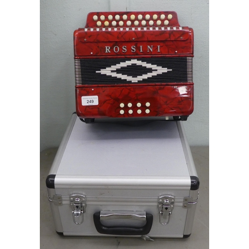 70 - A Rossini red marbleised effect cased button Melodeon with a hard carrying case