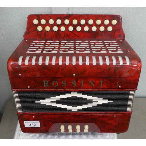 70 - A Rossini red marbleised effect cased button Melodeon with a hard carrying case