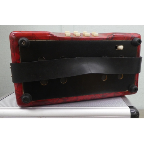 70 - A Rossini red marbleised effect cased button Melodeon with a hard carrying case