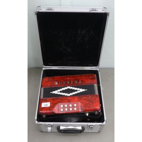 70 - A Rossini red marbleised effect cased button Melodeon with a hard carrying case