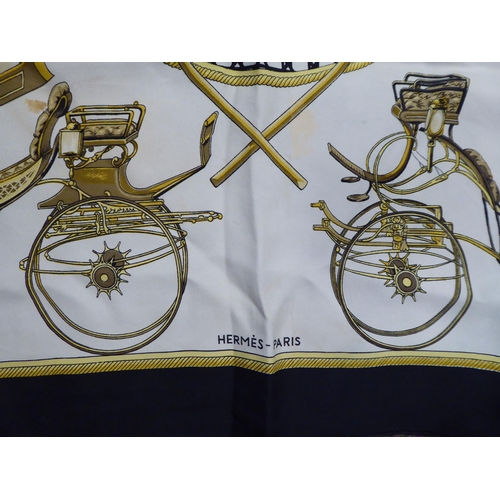 100 - A Hermes black, cream and gold coloured silk scarf  'Les Voitures a Transformation'  36