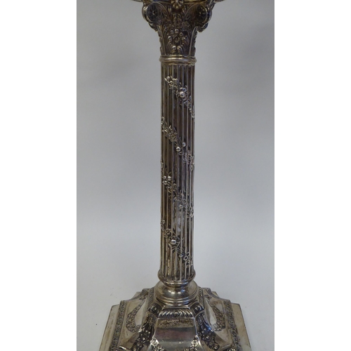 102 - A pair of late Victorian silver, two part candelabrum, each comprising twin scrolled branches, aroun... 