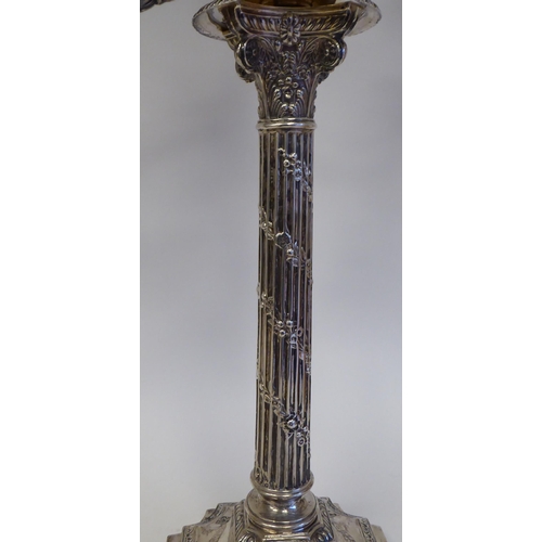 102 - A pair of late Victorian silver, two part candelabrum, each comprising twin scrolled branches, aroun... 