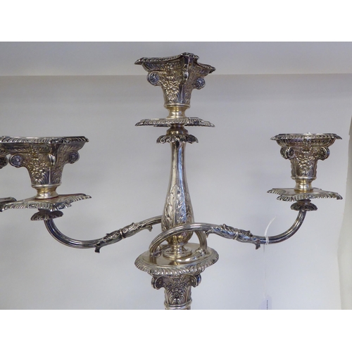 102 - A pair of late Victorian silver, two part candelabrum, each comprising twin scrolled branches, aroun... 