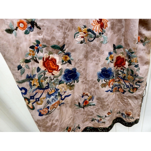 19 - A Chinese embroidered pink silk robe, lined in pale pink and woven in colours, featuring floral desi... 