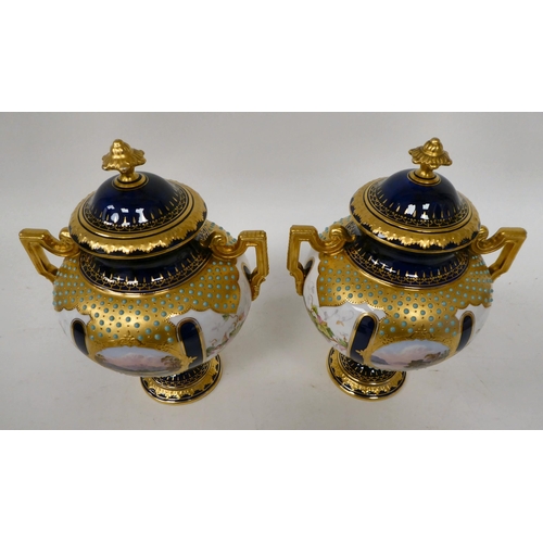 20 - A pair of 20thC Coalport china, twin handled pedestal vases and covers, in midnight blue and gilding... 