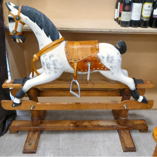 248 - An early 20thC overpainted nursery rocking horse, on an oak plinth  38