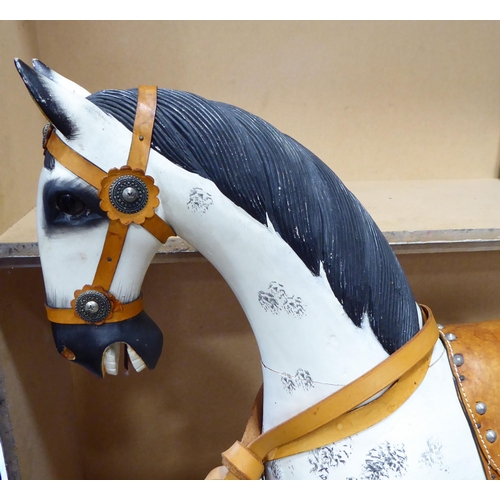 248 - An early 20thC overpainted nursery rocking horse, on an oak plinth  38