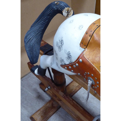 248 - An early 20thC overpainted nursery rocking horse, on an oak plinth  38