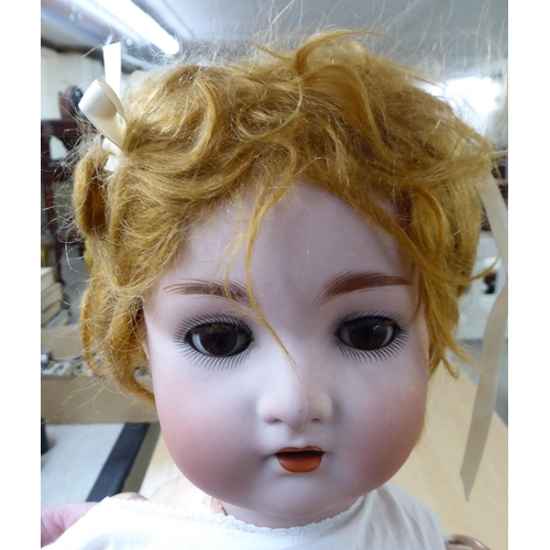 252 - Dolls: to include an early 20thC Thuringia Bisque head example with painted features and weighted sl... 