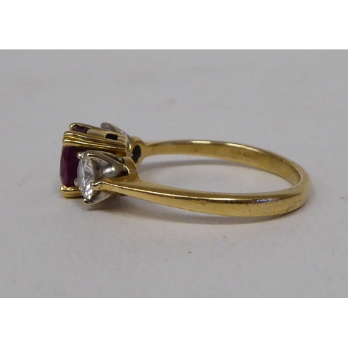 59 - A gold coloured metal ring, claw set with a diamond and a ruby 