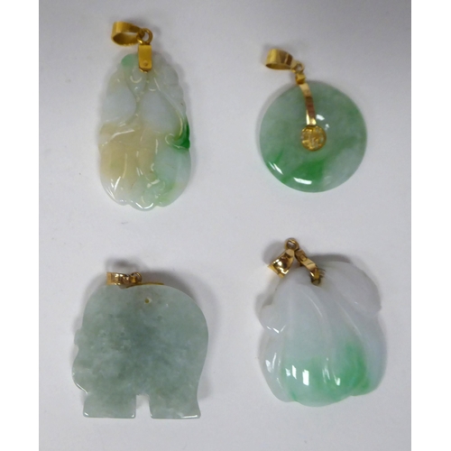 91 - Four similar carved jade pendants, on gold fittings  stamped 14k