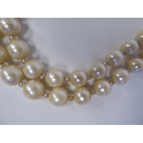 93 - Christian Dior, viz. a double strand, simulated pearl necklace, on an S-design clasp, in an original... 