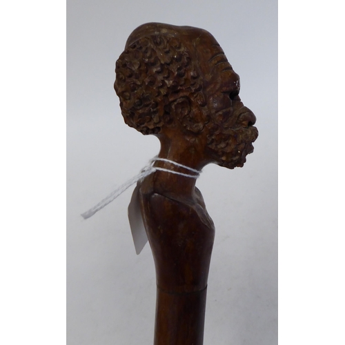 95 - An Aboriginal hardwood walking stick, the terminal fashioned as a finely carved man's head  40