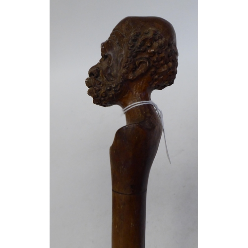 95 - An Aboriginal hardwood walking stick, the terminal fashioned as a finely carved man's head  40