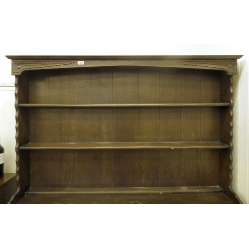 253 - A 20thC stained oak cottage dresser, the upper section with two open plate rack shelves, over two dr... 