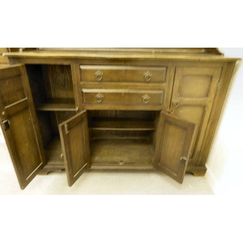 253 - A 20thC stained oak cottage dresser, the upper section with two open plate rack shelves, over two dr... 