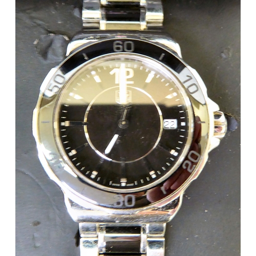 137 - A unisex Tag-Heuer stainless steel cased and strapped wristwatch, faced by a baton dial with a date ... 