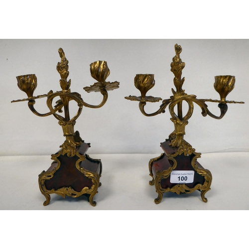 100 - A late 19thC French gilt metal mounted and laminated, three piece clock garniture with ornately cast... 