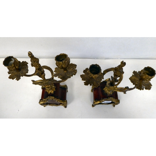 100 - A late 19thC French gilt metal mounted and laminated, three piece clock garniture with ornately cast... 