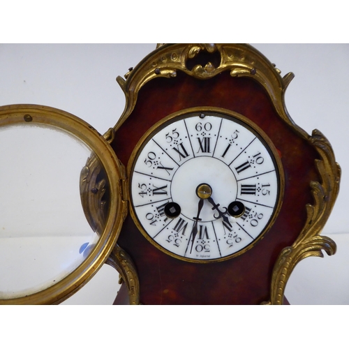 100 - A late 19thC French gilt metal mounted and laminated, three piece clock garniture with ornately cast... 