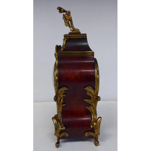 100 - A late 19thC French gilt metal mounted and laminated, three piece clock garniture with ornately cast... 