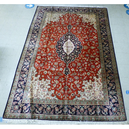 120 - A Qum design silk rug, decorated with a central medallion, surrounded and bordered by floral and bir... 