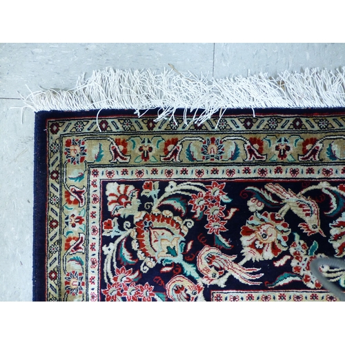 120 - A Qum design silk rug, decorated with a central medallion, surrounded and bordered by floral and bir... 