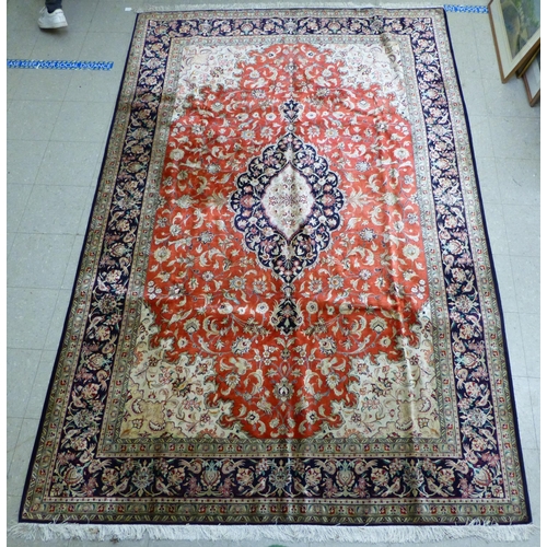 120 - A Qum design silk rug, decorated with a central medallion, surrounded and bordered by floral and bir... 