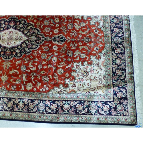 120 - A Qum design silk rug, decorated with a central medallion, surrounded and bordered by floral and bir... 