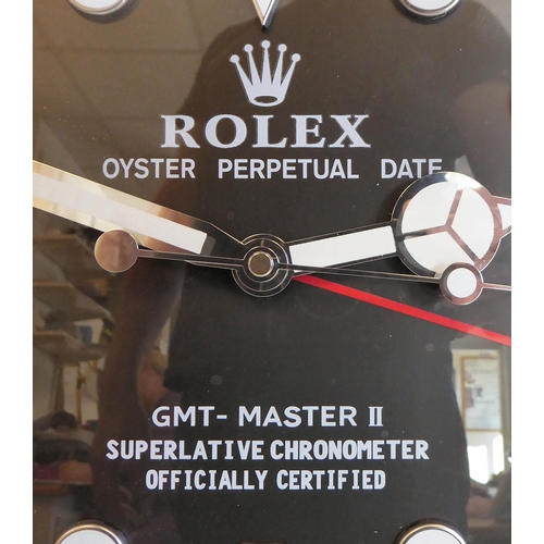 65 - A dealer display advertising wall timepiece for 'Rolex Oyster Perpetual', faced by a black baton dia... 