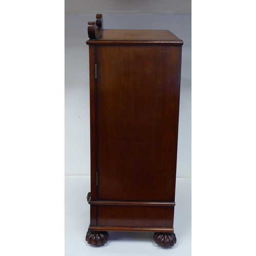 83 - A William IV mahogany, lockable table cabinet, the pointed arched top with carved ornament, over a p... 