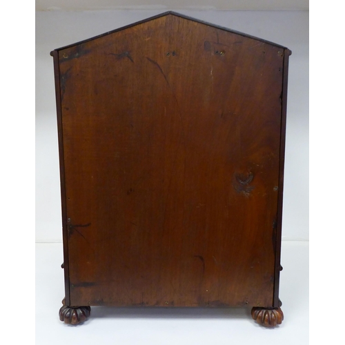 83 - A William IV mahogany, lockable table cabinet, the pointed arched top with carved ornament, over a p... 