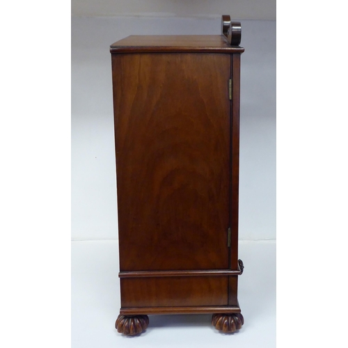 83 - A William IV mahogany, lockable table cabinet, the pointed arched top with carved ornament, over a p... 