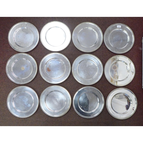 94 - A matched set of twelve silver plated, bead bordered platters  12