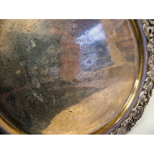 97 - An Edwardian silver waiter with a raised shell and scroll cast border, on conforming feet  bears a p... 