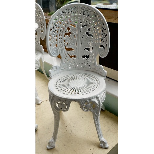 116 - A late Victorian, later white painted, five piece cast iron terrace set  comprising a table, ornamen... 