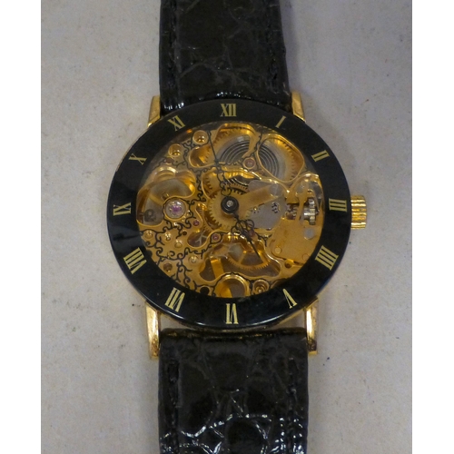 24 - A modern gold plated manual skeleton wristwatch, faced by a Roman dial