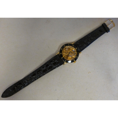 24 - A modern gold plated manual skeleton wristwatch, faced by a Roman dial
