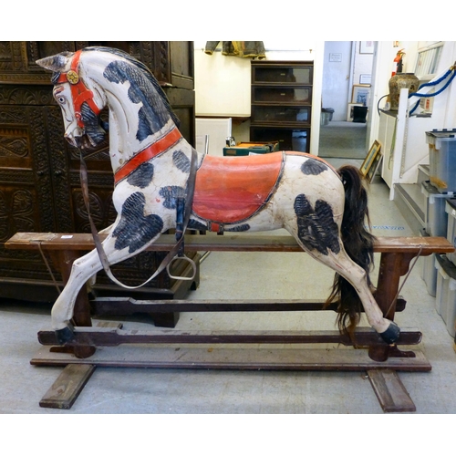 254 - A painted resin rocking horse, on a wooden trestle stand&nbsp; 50