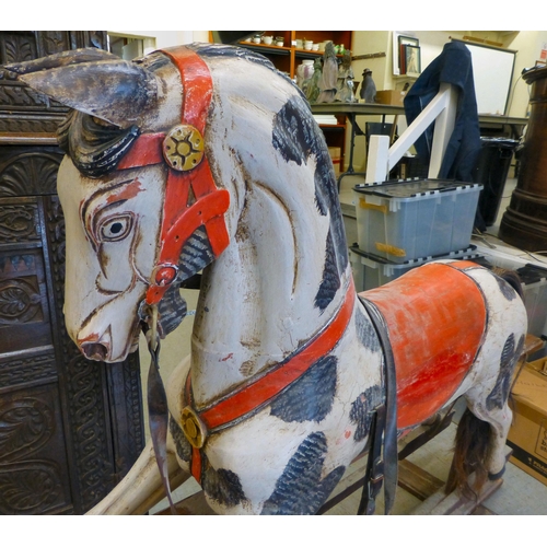 254 - A painted resin rocking horse, on a wooden trestle stand&nbsp; 50