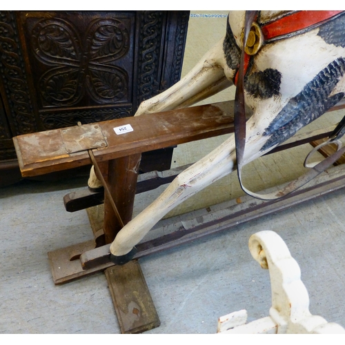 254 - A painted resin rocking horse, on a wooden trestle stand&nbsp; 50