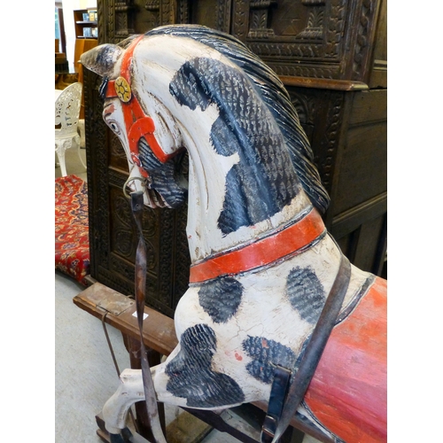 254 - A painted resin rocking horse, on a wooden trestle stand&nbsp; 50