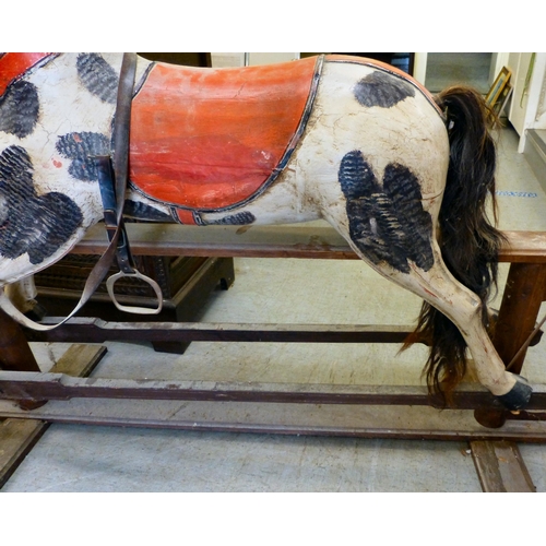 254 - A painted resin rocking horse, on a wooden trestle stand&nbsp; 50