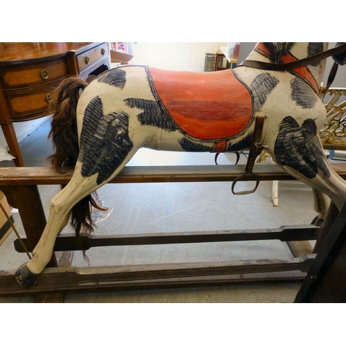 254 - A painted resin rocking horse, on a wooden trestle stand&nbsp; 50